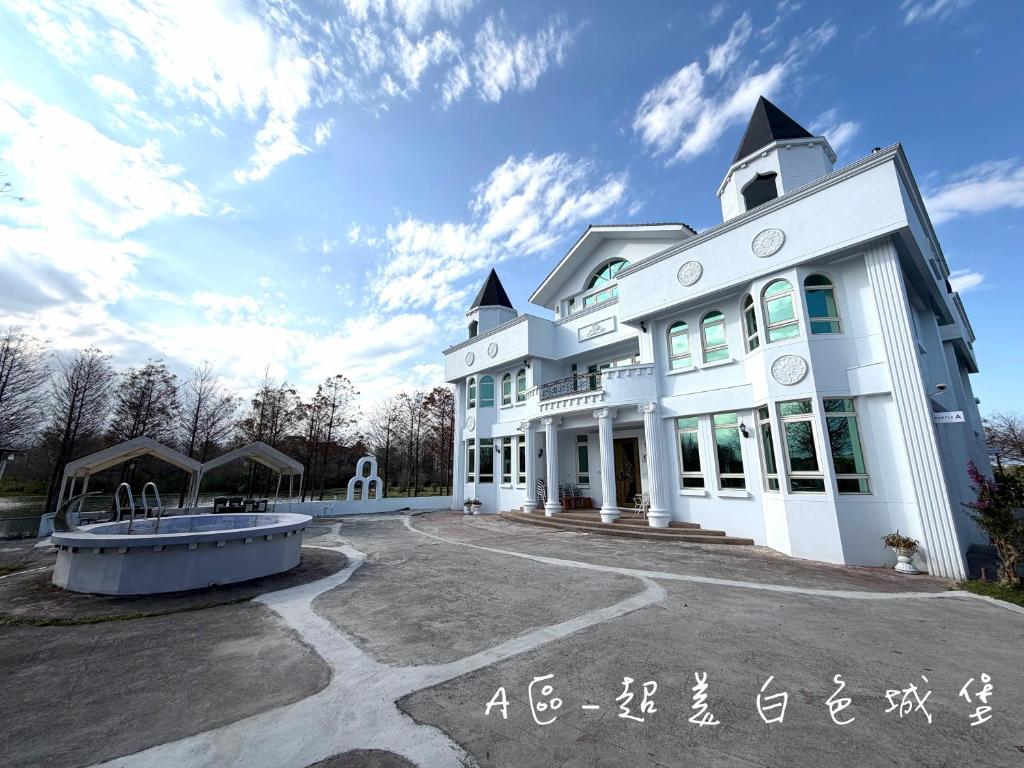 a large white building with a fountain in front of it at 夢幻城堡民宿 in Wujie