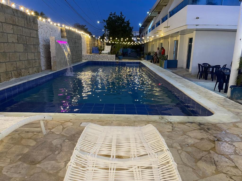 a swimming pool with a white bench in front of a building at Palmarena in Puerto Viejo