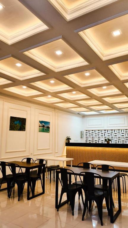 a room with tables and chairs and a coffered ceiling at azafa hotel in Lamobuang