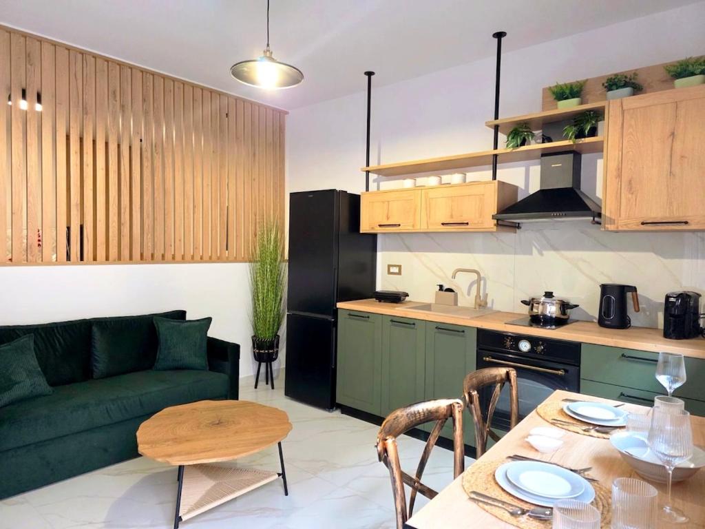 a living room with a green couch and a table at Anthouli Homes 2, steps from beach and centre in Kardamaina