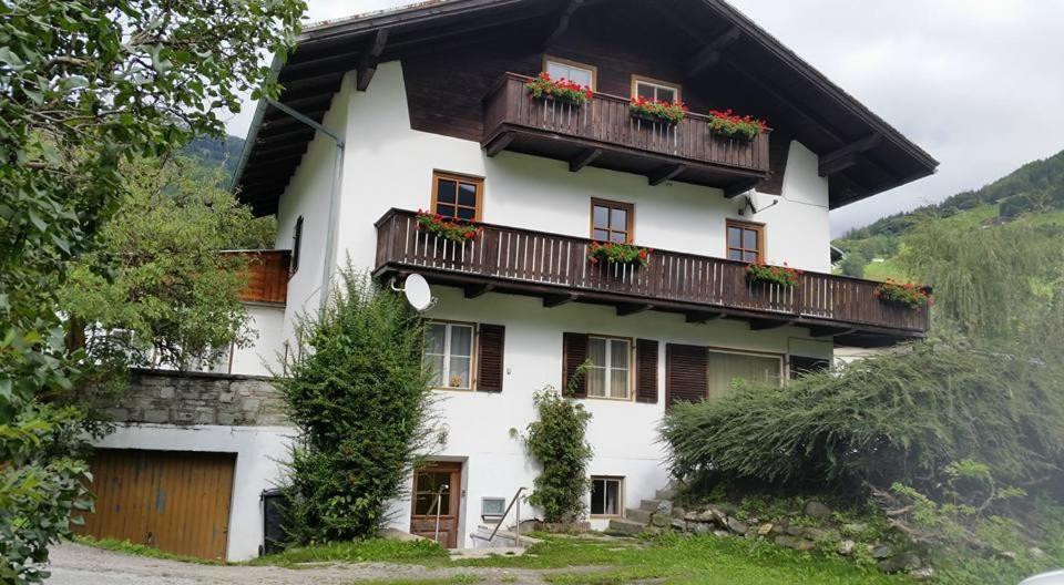 a white house with a balcony with flowers on it at Haus Ollie in Matrei in Osttirol