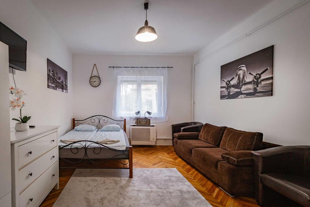 a living room with a couch and a bed at LénApartman - Holiday in Pécs
