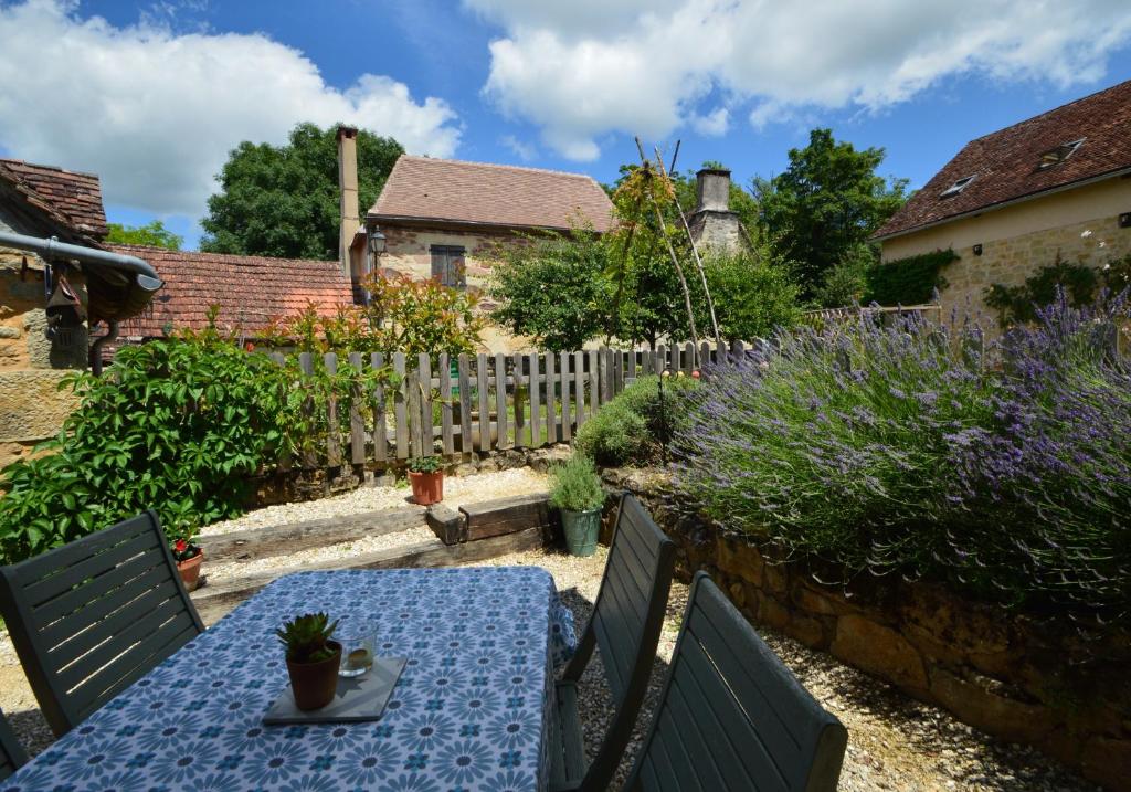 a patio with a blue table and a fence at Joli Canard in Badefols-dʼAns