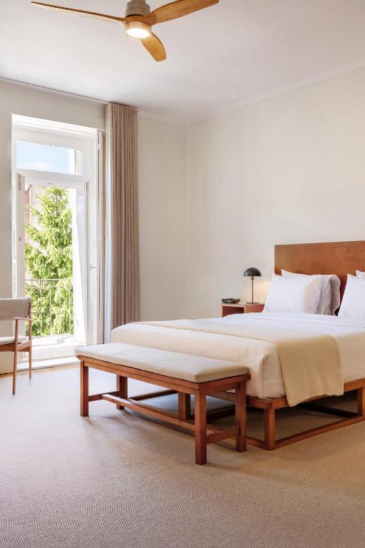 a bedroom with a large bed and a bench at Rosário Suites Townhouse in Porto