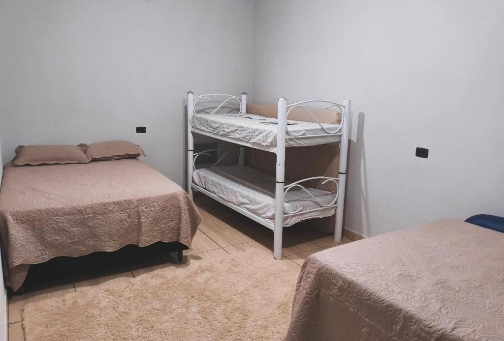 a bedroom with two beds and a white bunk bed at Área de Lazer BR 267 in Bataguaçu