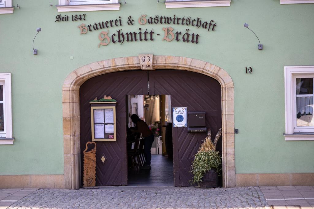 a door to a store with a person walking into it at Schmitt Bräu - Hotel und Brauereigasthof in Scheßlitz