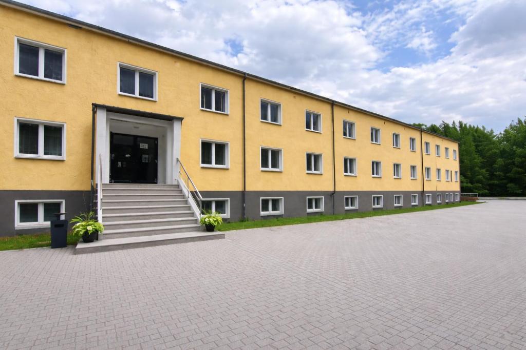 a large yellow building with stairs and a door at A2rooms in Lehnin