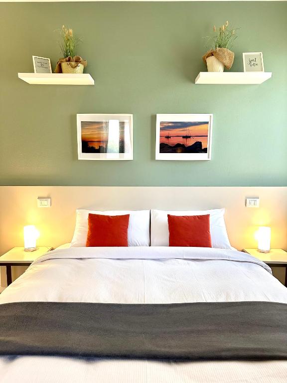 a bedroom with a bed with two tables and two plants at VeronaLago B&B Accessibile in Bussolengo