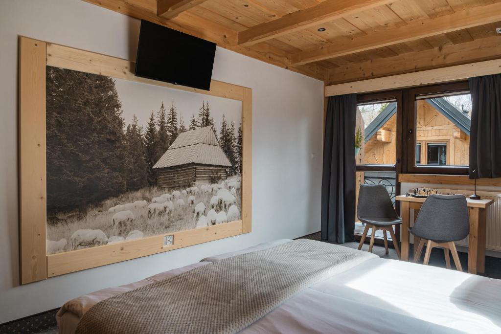 a bedroom with a large picture of sheep on the wall at Chocholowska Zohylina pokoje in Chochołów