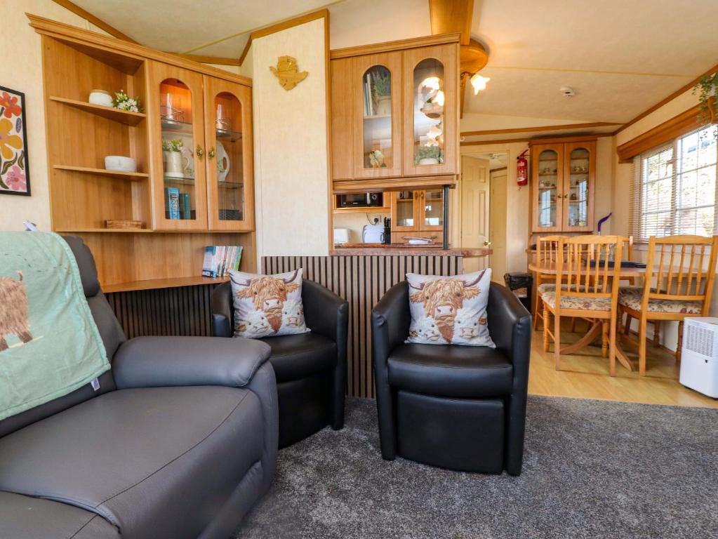 a living room with two chairs and a table at The Granada at Argraig in Holyhead