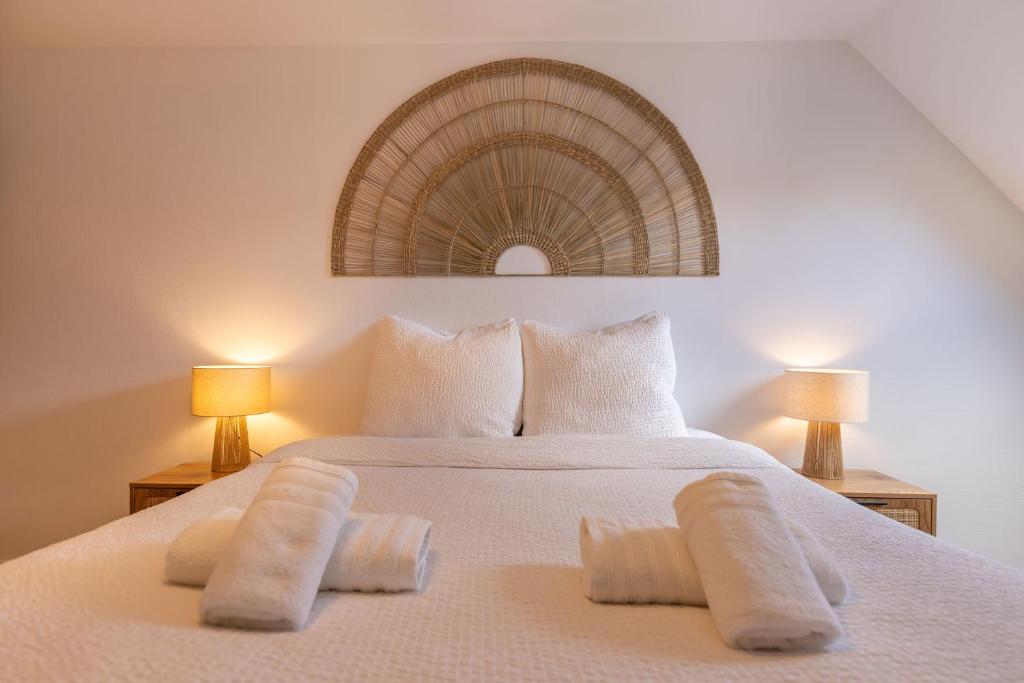 a bedroom with a white bed with two lamps at Le Grenier cocoon in Romorantin