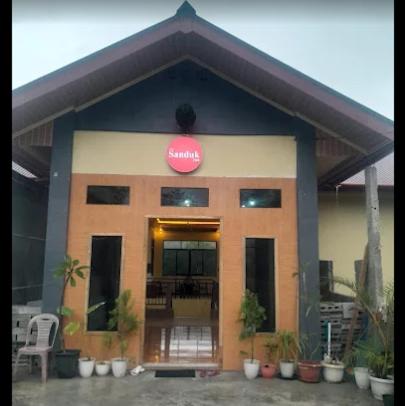 a building with a pink sign on the front of it at The Sanduk Inn in Rantepao