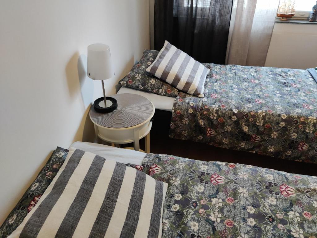 a room with two beds and a table with a stool at Yyterin portti in Pori