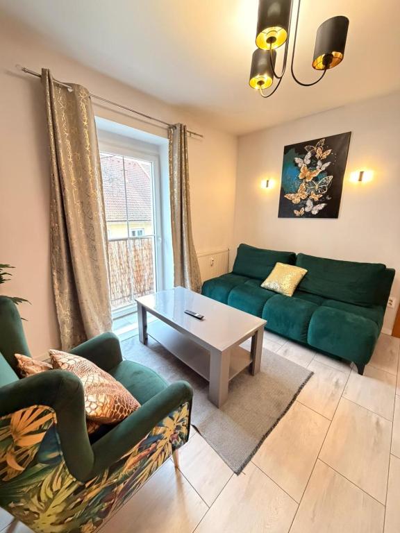 a living room with a green couch and a table at Aura centrum in Piešťany