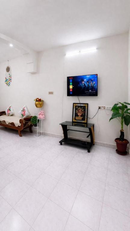 a living room with a flat screen tv on a wall at Vasan villa 2BHK in Pondicherry