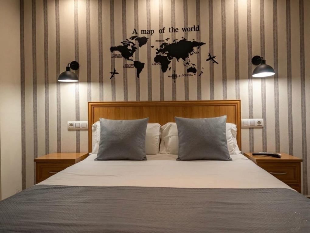 a bedroom with a bed with a map of the world at Hospedería Puerta de la Catedral in Ciudad-Rodrigo