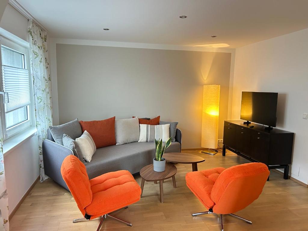 a living room with a couch and two chairs at MühlengasseONE in Lenzing
