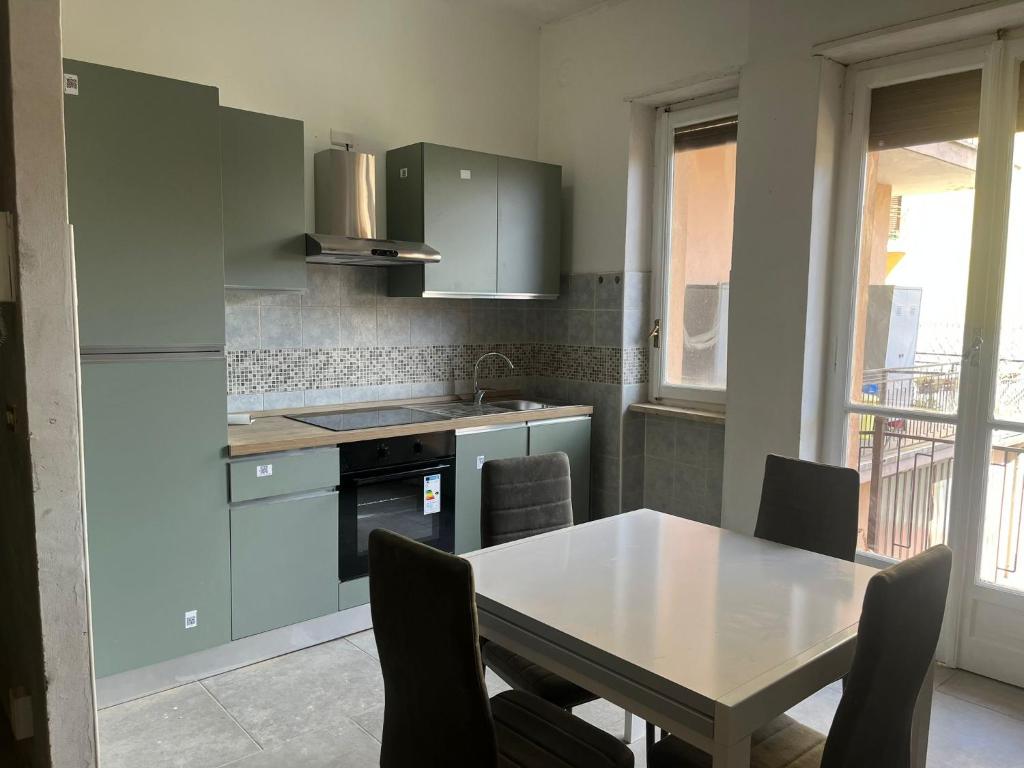 a kitchen with a table and a table and chairs at Alloggio Tommy in Biella