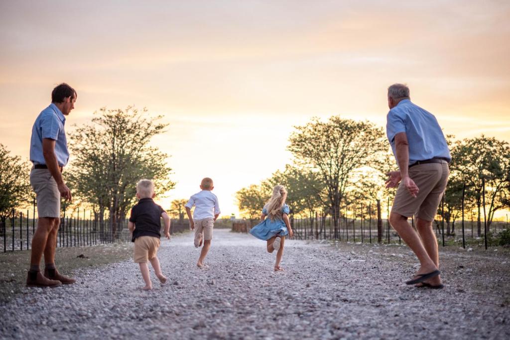 a group of people playing frisbee in a field at Tarentaal Guest Farm Etosha National Park Namibia in Okaukuejo