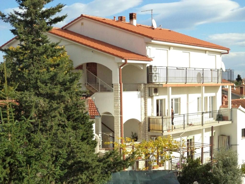 un edificio bianco con un albero di fronte di Two-Bedroom Apartment in Pula II a Veruda