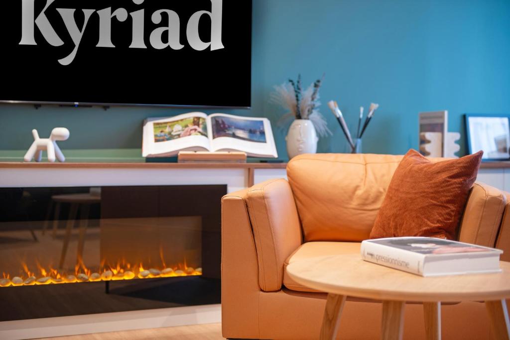 a living room with a chair and a fireplace at Kyriad Argenteuil in Argenteuil