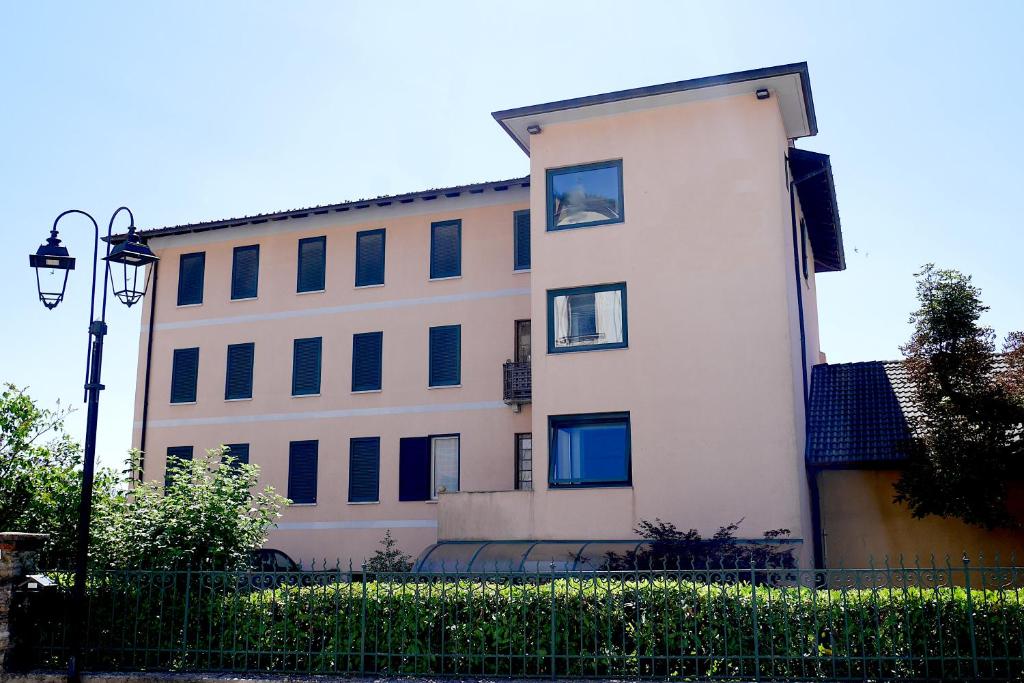 a tall white building with a black fence at vitalArmonie Retreat in Marzio