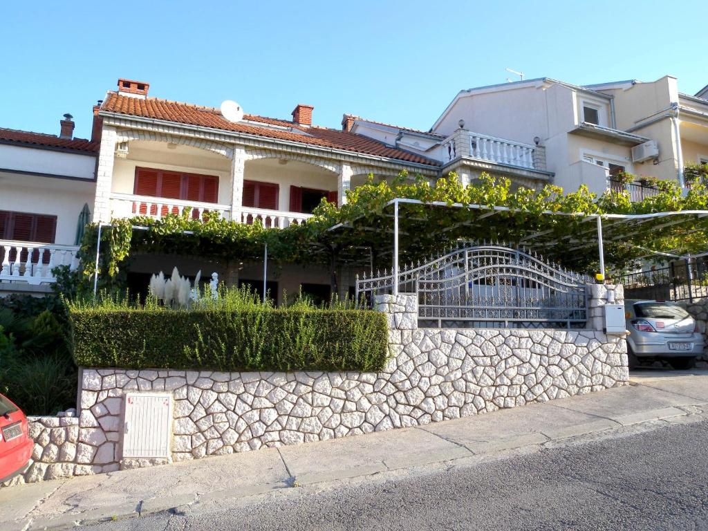 a house with a stone wall and a fence at Apartment Crikvenica 6 in Crikvenica