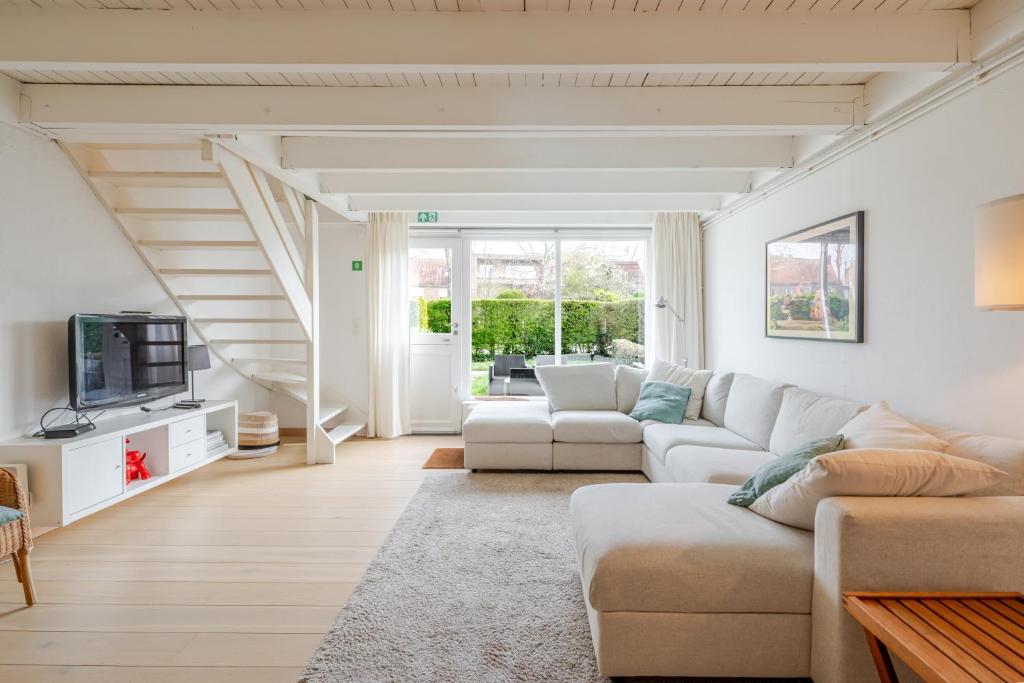a living room with a couch and a tv at Aalduiker 7 in Nieuwpoort