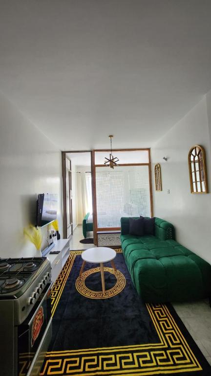 a living room with a green couch and a table at nook in Ongata Rongai 