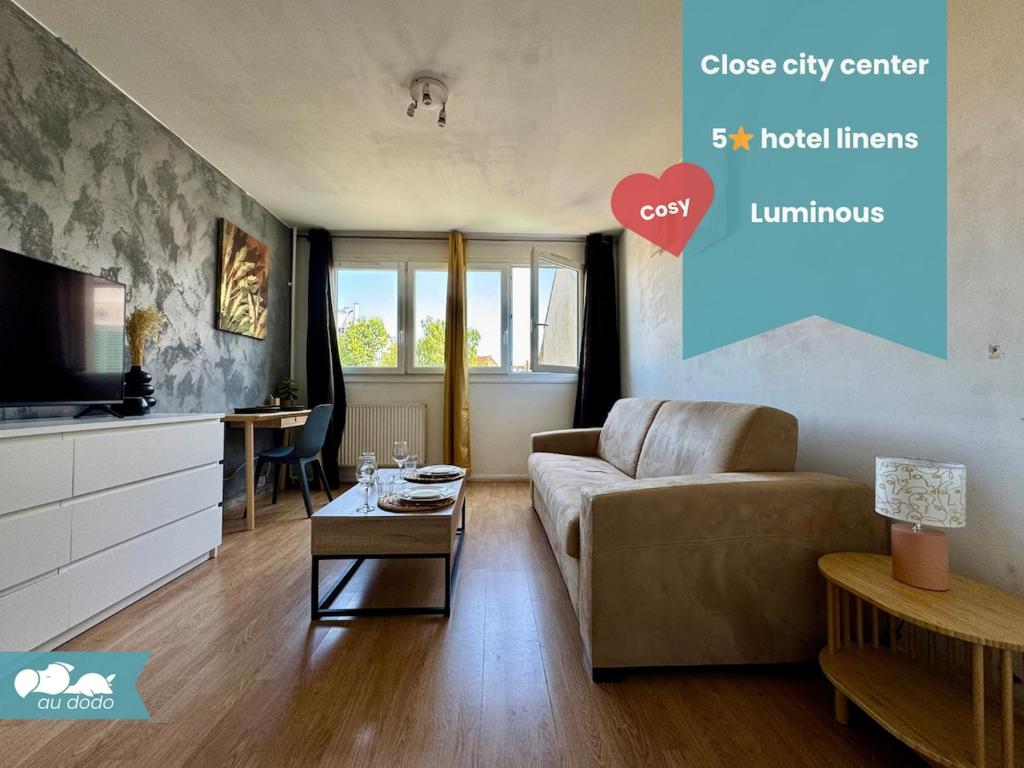 a living room with a couch and a tv at Cosy studio centre-ville & RER A in Saint-Germain-en-Laye