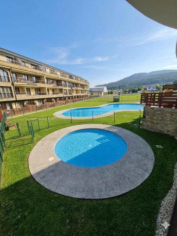 a large swimming pool in front of a building at Playa Reinante SPA in Barreiros