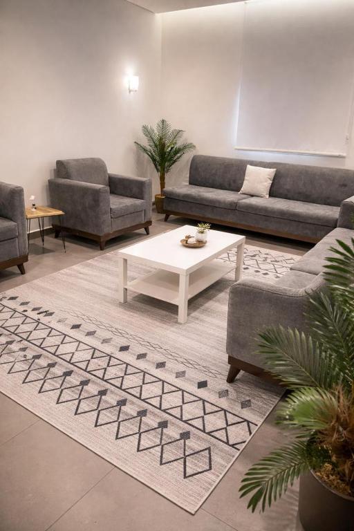 a living room with couches and a coffee table at Najd APARTMENTS in Al-ʿUla
