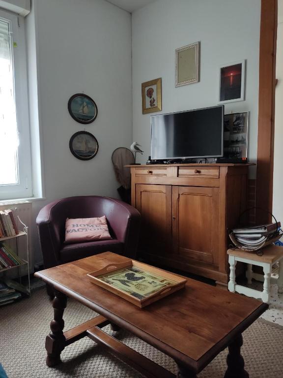 a living room with a coffee table and a tv at maison entière in Fécamp