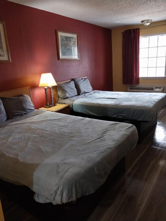 two beds in a hotel room with red walls at Gated 2 Queen Beds Hotel Room 257 in Jackson