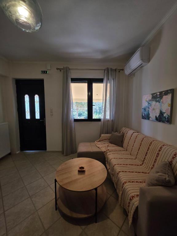 a living room with a couch and a table at Christos Sunhaven Apartment in Agia Ermioni