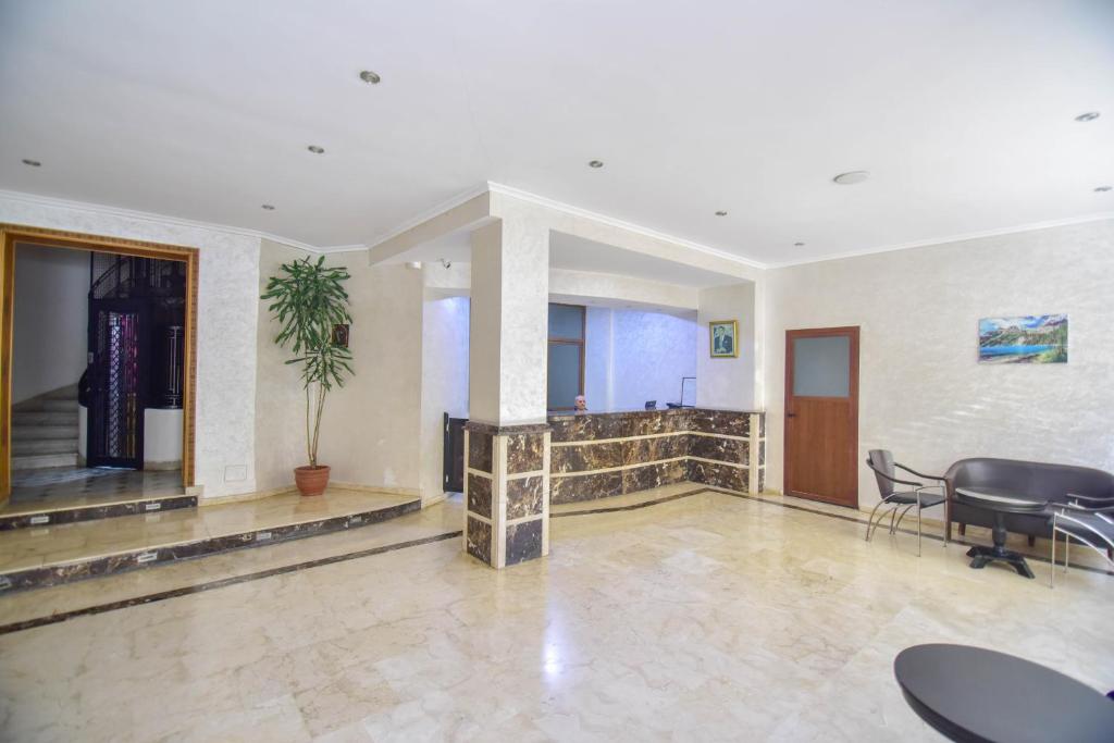 a lobby with a table and chairs in a building at Hôtel Atlas in Tangier
