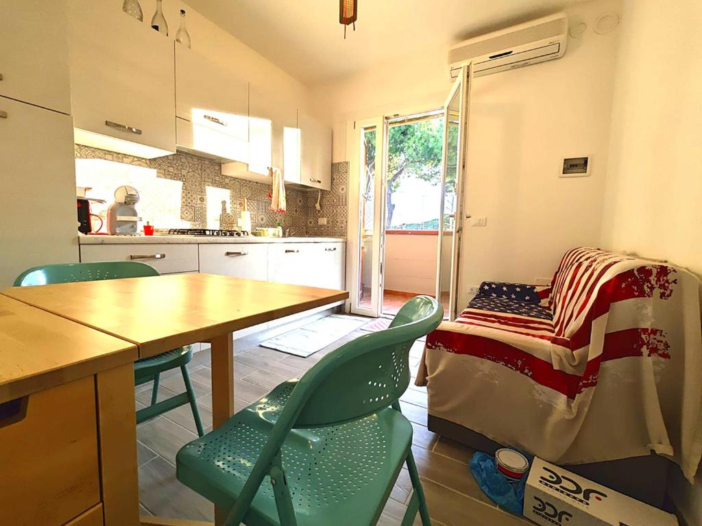 a kitchen with a table and chairs and a bed at Piazzetta 293 in Rosolina Mare