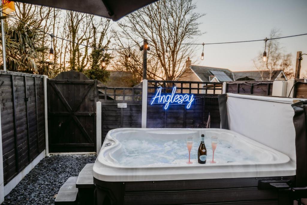 a jacuzzi tub with a sign that reads happy at Pauls Place in Brynsiencyn