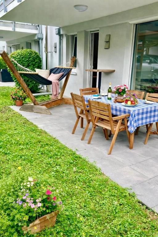 a patio with a table and chairs and a hammock at Zentrales Apartment in Friedrichshafen mit Terrasse für bis zu 5 Personen in Friedrichshafen