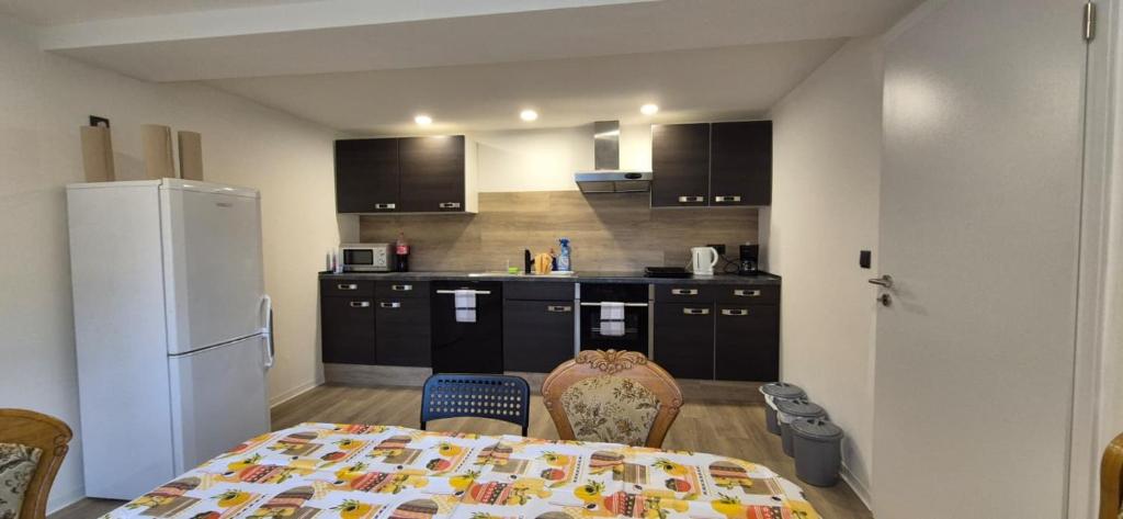 a kitchen with a table and a white refrigerator at Ferien- & Monteurwohnung Stößen in Stößen