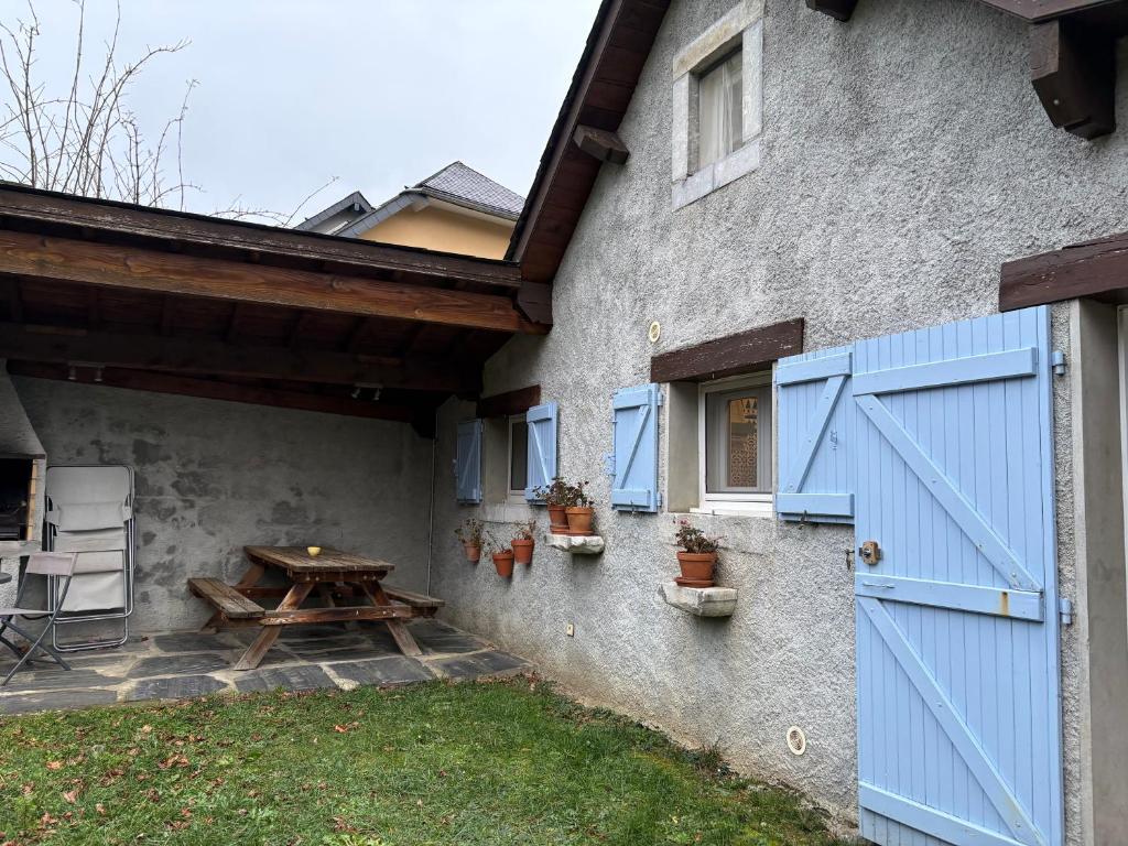 a house with blue doors and a picnic table at Appartement 4 personnes - Laruns in Laruns