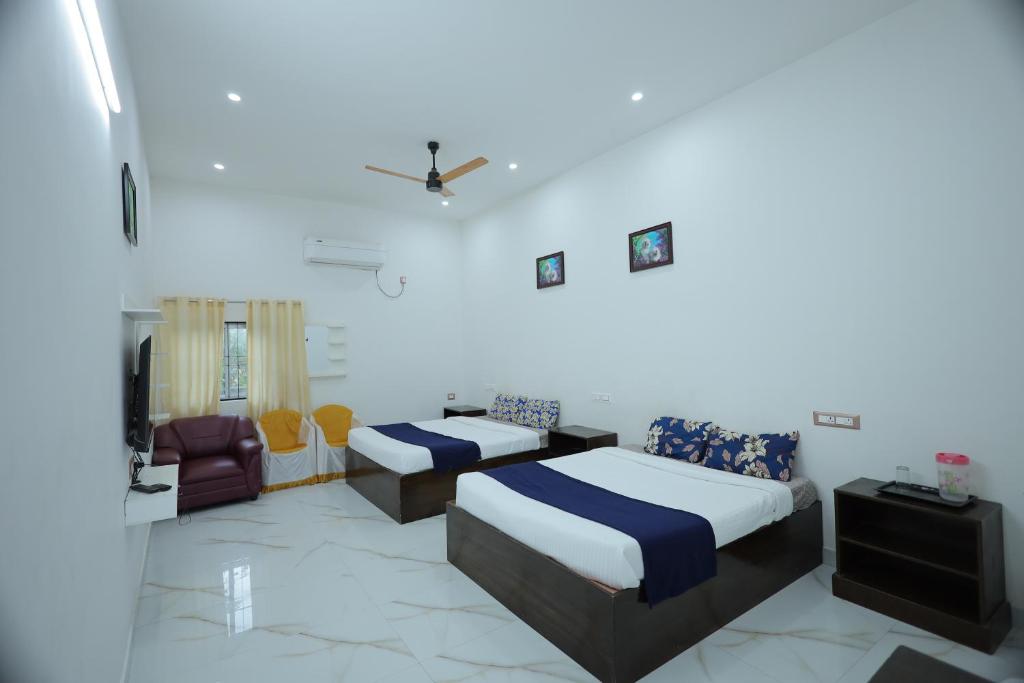 a hotel room with two beds and a couch at LK.Lodge in Kanyakumari