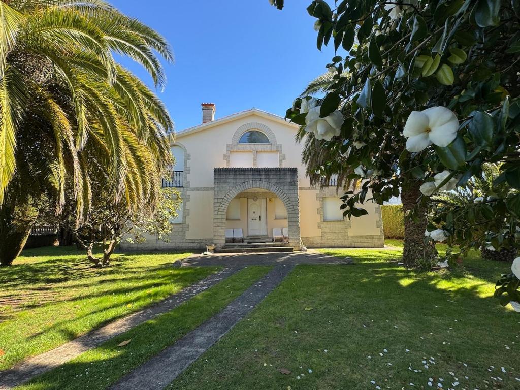 a house with a palm tree in front of it at La Zinca in Cambre