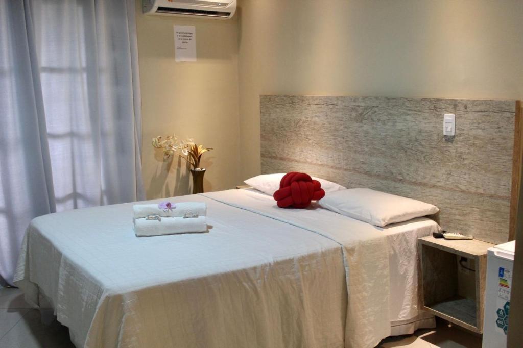 a bedroom with a bed with a red teddy bear on it at Suíte Atobás in Arraial do Cabo