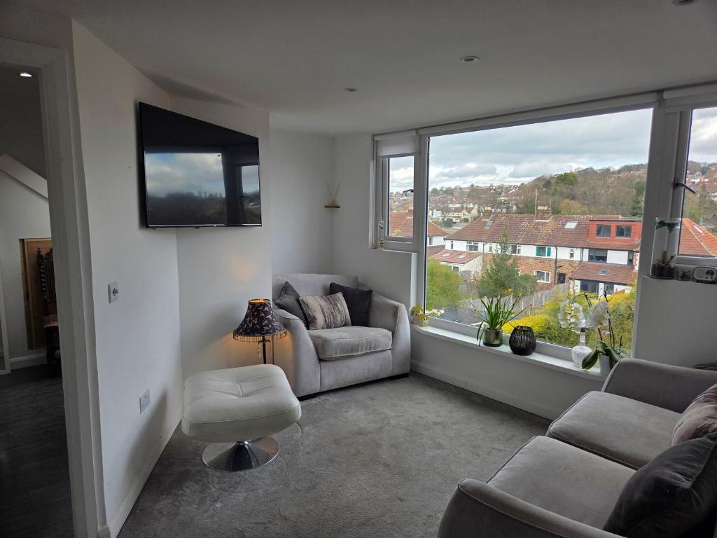 a living room with two chairs and a large window at The Fox Apartment LBA in Horsforth