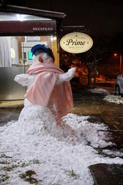 a snowman is standing in a pile of snow at Pousada Prime Gramado in Gramado
