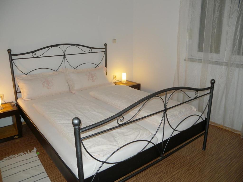 a bed with a black metal frame and white sheets at Apartment Liznjan 3 in Ližnjan