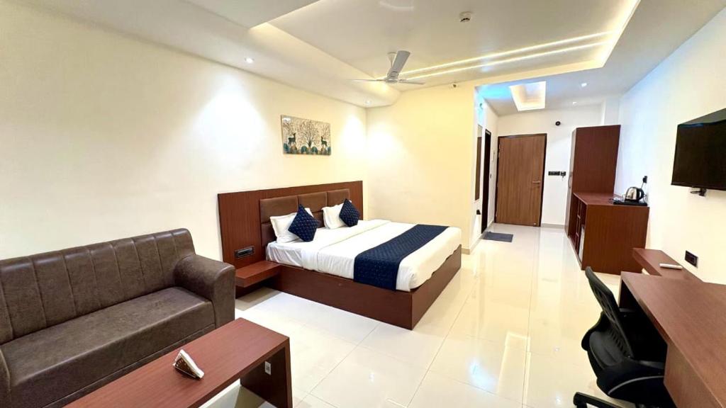 a hotel room with a bed and a couch at Hotel Parv Vilas in Behror