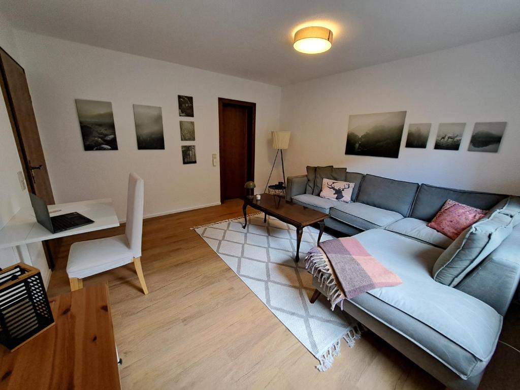 ein Wohnzimmer mit einem blauen Sofa und einem Tisch in der Unterkunft Gemütliche Fewo "Schellings Ruhe" in Sundern
