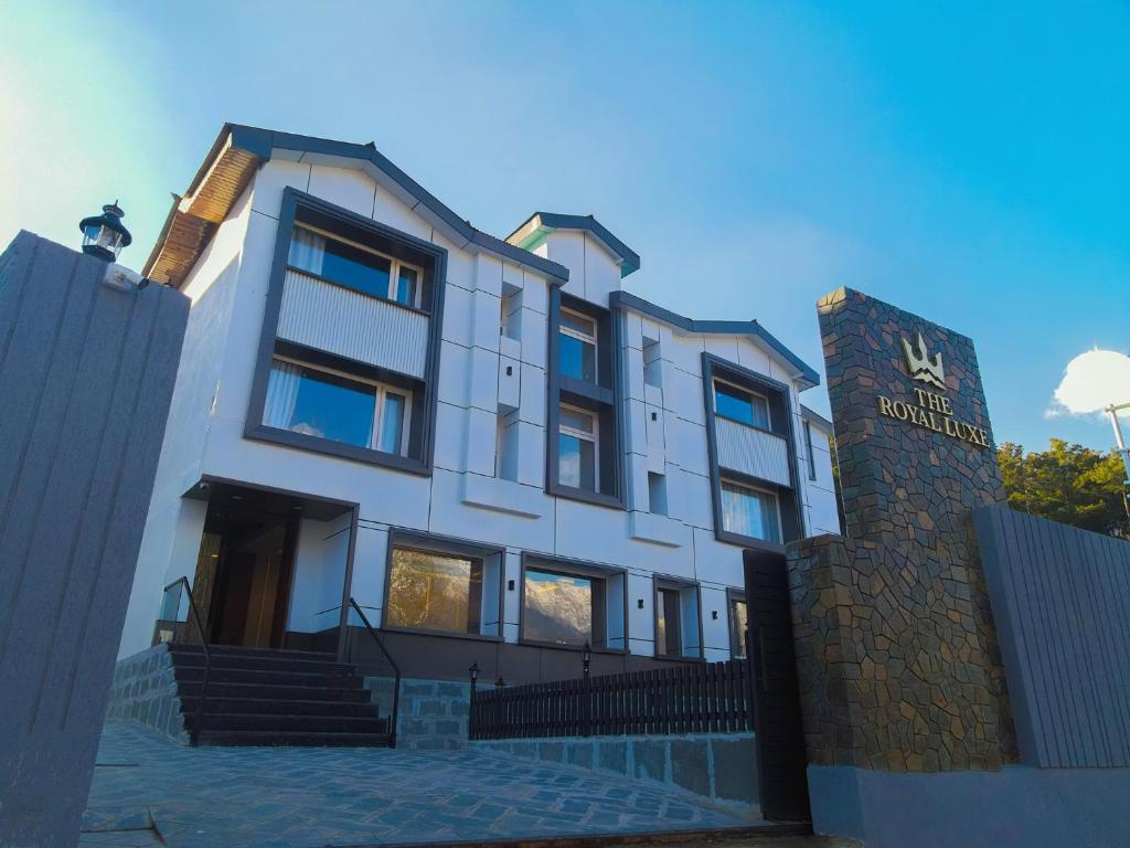 a white building with a sign in front of it at The Royal Luxe in Kolur